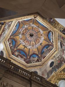 eine verzierte Decke eines Gebäudes mit einer Uhr darauf in der Unterkunft Pensione Delfino Azzurro in Loreto