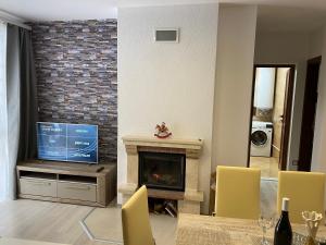 uma sala de estar com lareira e televisão em Апартамент в комплекс Смолянски езера em Smolyan