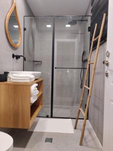a bathroom with a shower and a sink and a mirror at Urbanica Carmel- Apartments in Haifa