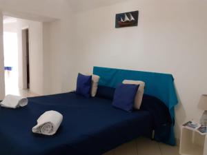 a blue bed with blue sheets and pillows at Emidio House in Termini