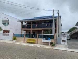 un edificio con un banco amarillo en una calle en Pousada cantinho do Descanso, en Penha