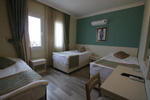 a hotel room with two beds and a table at Artemis Hotel in Bodrum City