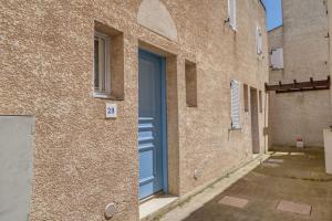 una porta blu sul lato di un edificio di Location Le Samaria Villa 29 - Mail de Rochelongue a Cap d'Agde