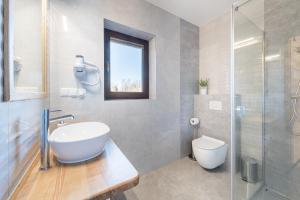 a bathroom with a sink and a toilet and a glass shower at Apartamenty ARNIKA in Jurgów +24 photos