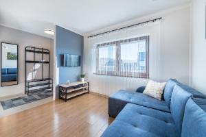 a living room with a blue couch and a table at Apartamenty ARNIKA in Jurgów