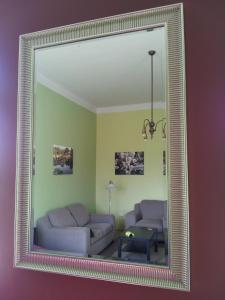 a mirror reflecting a living room with a couch and a table at Studio along the Danube in Budapest