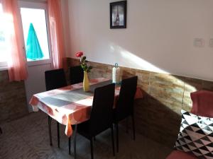 a dining room table with chairs and a vase on it at Apartment Buic in Pula