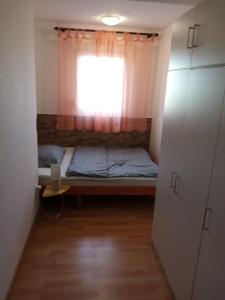 a small room with a bed and a window at Apartment Buic in Pula
