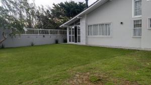 un patio frente a una casa blanca en Casa com piscina, en Florianópolis