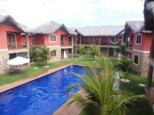a villa with a swimming pool in front of a house at Chale Canoa Quebrada La Fazenda in Canoa Quebrada