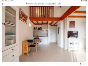 eine Küche mit weißen Schränken und einem Tisch mit Stühlen in der Unterkunft Superbe appartement T1 duplex,vue mer in La Croix-Valmer
