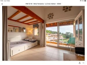 ein Schlafzimmer mit einem Bett und einem großen Fenster in der Unterkunft Superbe appartement T1 duplex,vue mer in La Croix-Valmer + 21 Fotos