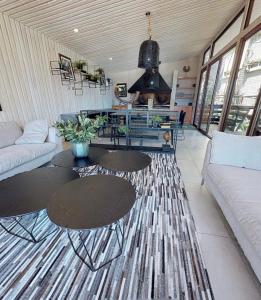 un soggiorno con due tavoli e un divano di Departamento Pucon espectacular a Pucón