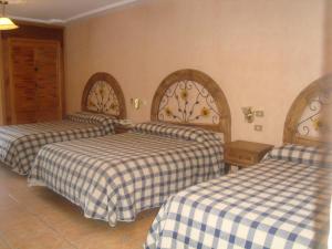 a hotel room with two beds with checkered sheets at Hotel Villa Manzanares in Aguascalientes