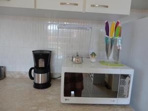 a kitchen counter with a coffee maker and a microwave at Chale Canoa Quebrada La Fazenda in Canoa Quebrada
