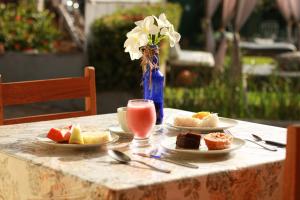 a table with plates of food and a glass of juice at Pousada Vila do Mar in São Luís