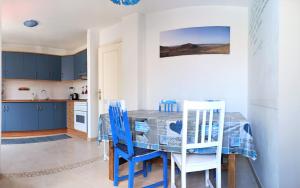 una cucina con armadi blu, tavolo e sedie di The Spot House a Corralejo