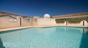 una piscina di fronte a un edificio di Location Le Samaria Villa 29 - Mail de Rochelongue a Cap d'Agde Altre 23 foto