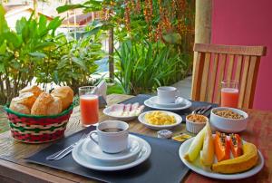 einen Tisch mit Frühstückszutaten und Getränken darauf in der Unterkunft TBS Prime Suítes in São Sebastião
