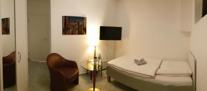 a small room with a bed and a chair at Sleep2Fly Hamburg-Airport in Hamburg +7 photos