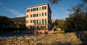 a large building next to a stone wall next to a building at Villa Rosmarino in Camogli