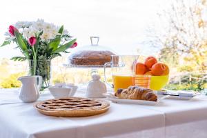 a white table with a breakfast of bread and orange juice at Villa Teresa Bed & Breakfast Costa degli Dei in Pannaconi