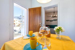 une table à manger avec un chiffon de table jaune et des verres dans l'établissement B&B AL MARE, à Alghero