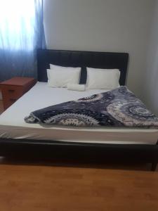 uma cama grande com uma cabeceira preta e almofadas brancas em SALAMA LODGE em Cidade do Cabo