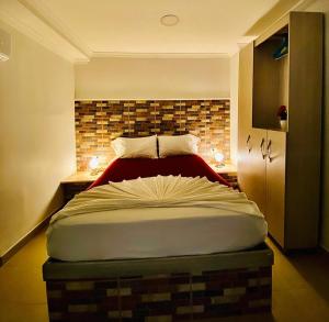 um quarto com uma cama grande e uma parede de tijolos em Hotel El Viajero Centro em Cartagena das Índias