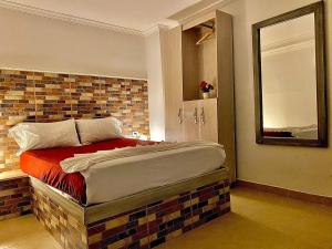 um quarto com uma cama com uma parede de tijolos em Hotel El Viajero Centro em Cartagena das Índias