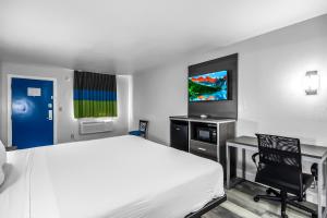 Schlafzimmer mit einem Bett, einem Schreibtisch und einem TV in der Unterkunft SureStay Hotel by Best Western Oklahoma City West in Oklahoma City