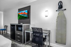 Cette chambre dispose d'un bureau, d'une chaise et d'une télévision. dans l'établissement SureStay Hotel by Best Western Oklahoma City West, à Oklahoma City