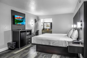a bedroom with a bed and a desk and a mirror at SureStay Hotel by Best Western Oklahoma City West in Oklahoma City
