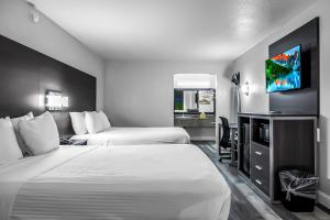 a hotel room with two beds and a flat screen tv at SureStay Hotel by Best Western Oklahoma City West in Oklahoma City