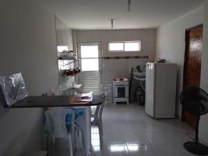 cocina con mesa y nevera en Residencial Água Viva Extra en Jacumã