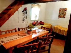 a dining room with a table and two beds at Cabañas Paqa Paqa in Maimará