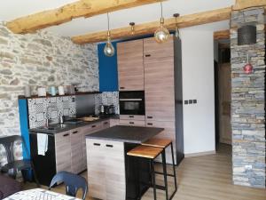 a kitchen with wooden cabinets and a counter top at Maison de l'Epine -spa- Versant du soleil in Granier