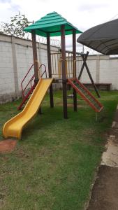 a playground with two slides in the grass at Residencial savassi in Betim
