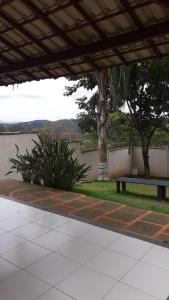 a park bench under a pavilion with a tree at Residencial savassi in Betim