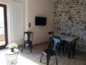 a dining room with a table and chairs and a stone wall at Maison de l'Epine -spa- Versant du soleil in Granier