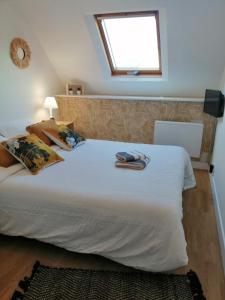 a bedroom with a large white bed with a window at Villa bord de mer avec piscine et jacuzzi in Pénestin