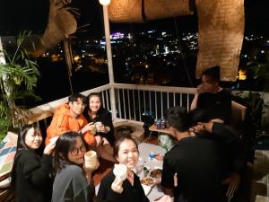 un gruppo di persone seduti su un balcone di notte di My Dream Hotel a Da Lat Altre 28 foto