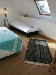 a room with two beds and a rug and a window at Villa bord de mer avec piscine et jacuzzi in Pénestin