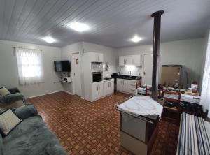 a living room with a couch and a kitchen at Aconchego da Vó Méia in Urubici