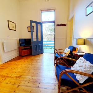 a living room with a blue door and a wooden floor at Point Lonsdale Guest House in Point Lonsdale