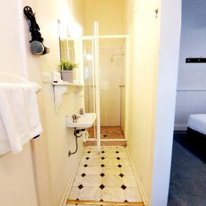 a small bathroom with a sink and a shower at Point Lonsdale Guest House in Point Lonsdale