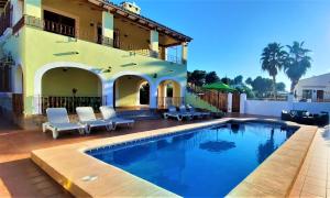 a swimming pool in front of a house at Villa Costa in Moraira