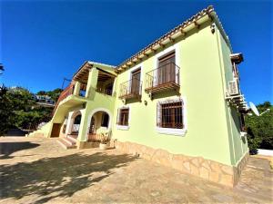 a large yellow house with two balconies on it at Villa Costa in Moraira