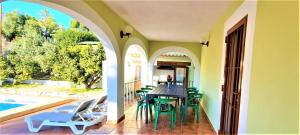 a patio with a table and chairs next to a swimming pool at Villa Costa in Moraira