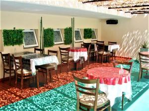 a dining room with tables and chairs on a rug at Hosteria Aguaribay in Mina Clavero